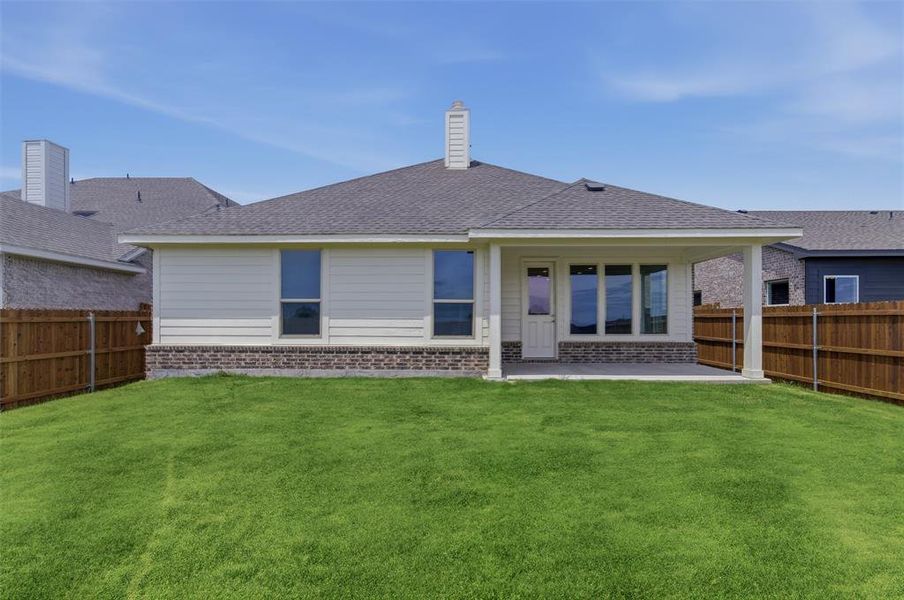 Expansive backyard with a covered patio and wood privacy fencing