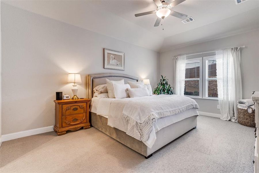 Carpeted bedroom with ceiling fan and vaulted ceiling Carpeted bedroom with ceiling fan and vaulted ceiling
