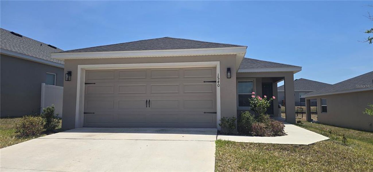 Front exterior of a new home in Geneva Landings, Davenport, FL, highlighting curb appeal (Image 14).