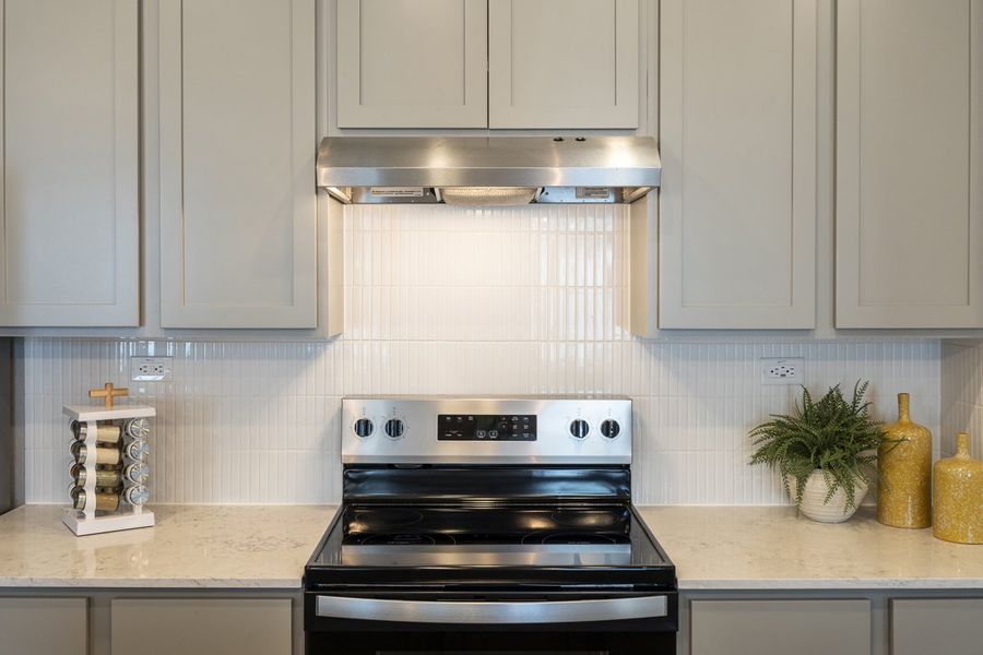 Glossy quartz countertops with vertical tile backsplash Glossy quartz countertops with vertical tile backsplash