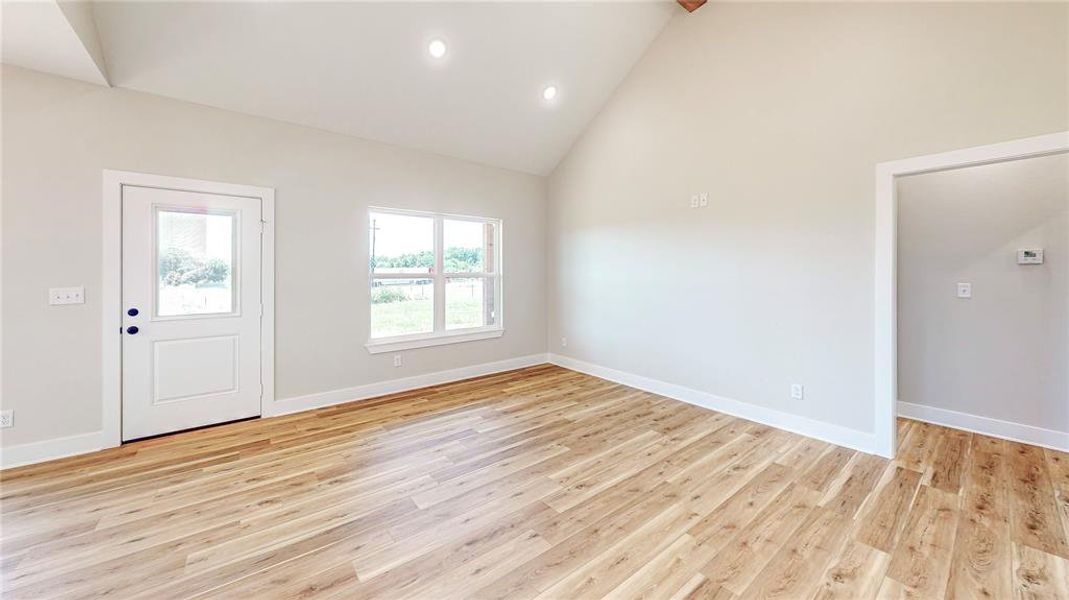 Foyer with high vaulted ceiling, light wood-type flooring, and recessed lighting Foyer with high vaulted ceiling, light wood-type flooring, and recessed lighting
