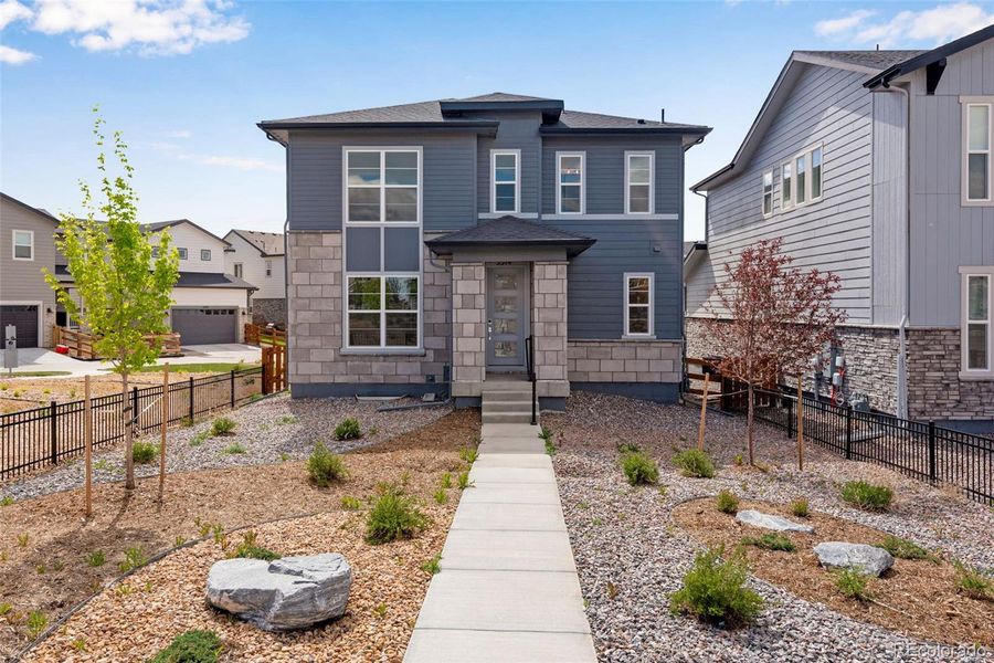 Front exterior of a new home in Crescendo at The Aurora Highlands, Aurora, CO, highlighting curb appeal (Image 21).