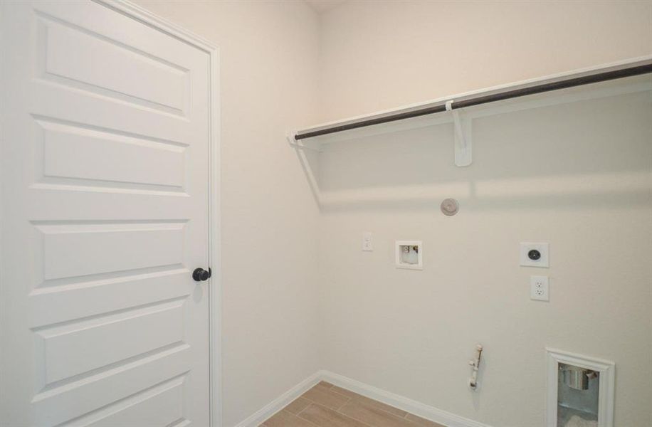 This laundry room offers ample space for all your needs, with dedicated hook-ups for washer and dryer, additional shelving for storage, and convenient location for ease of use.