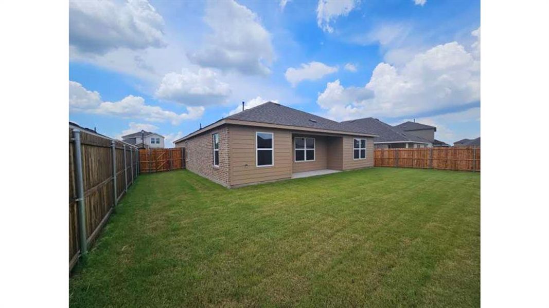 Expansive backyard featuring a manicured lawn and complete wood fencing Expansive backyard featuring a manicured lawn and complete wood fencing