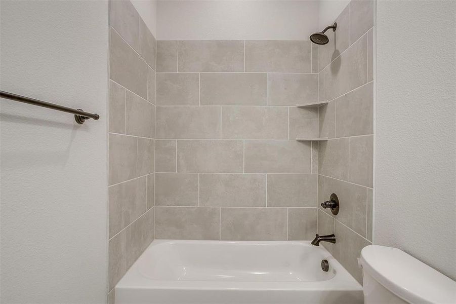 Bathroom featuring toilet and tiled shower / bath