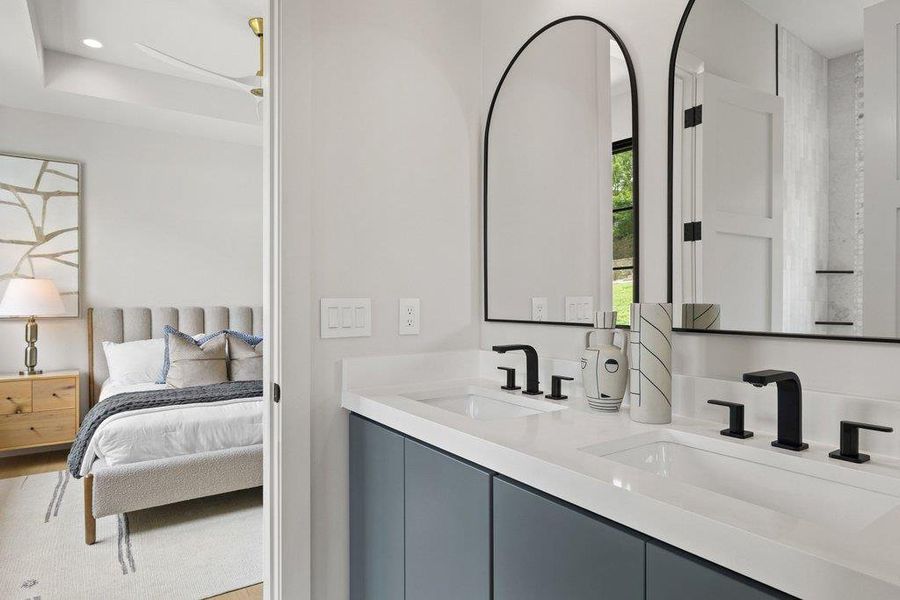 Dual vanity featuring integrated sinks, matte black fixtures, and arched mirrors