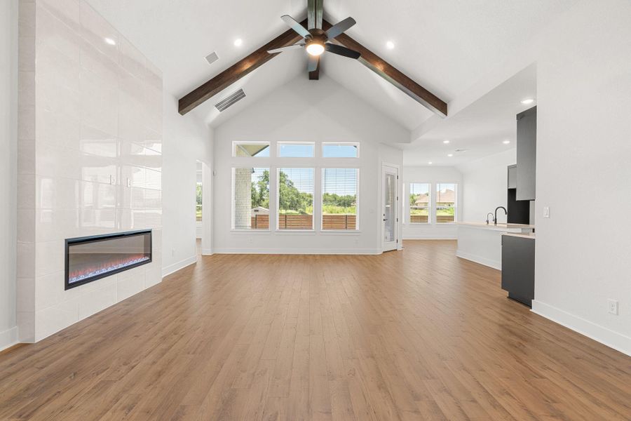 Vast, naturally illuminated living space features vaulted ceilings and an inviting modern fireplace.