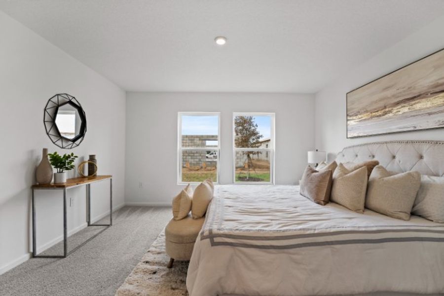 A bedroom with a bed and a chair.