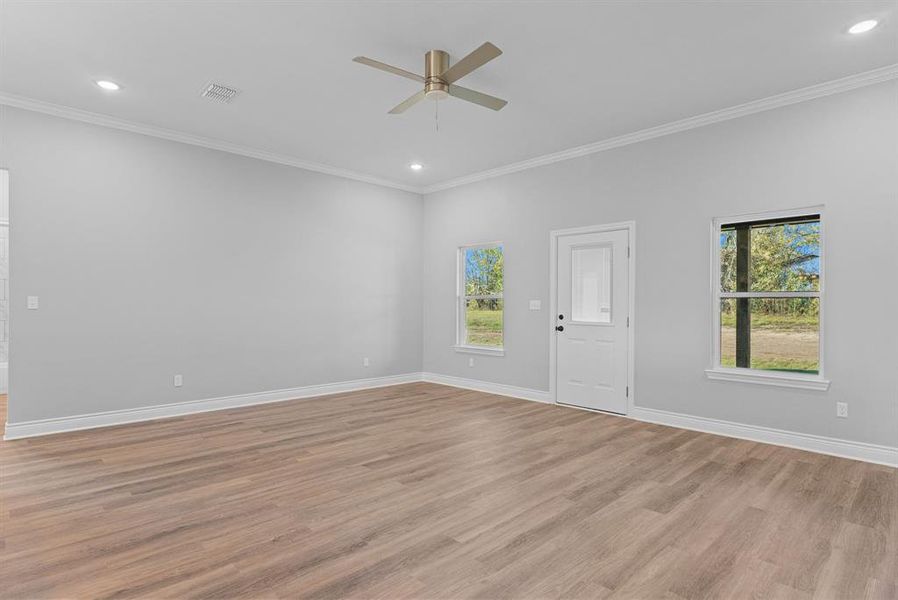 Empty room with light wood finished floors, crown molding, recessed lighting, and ceiling fan