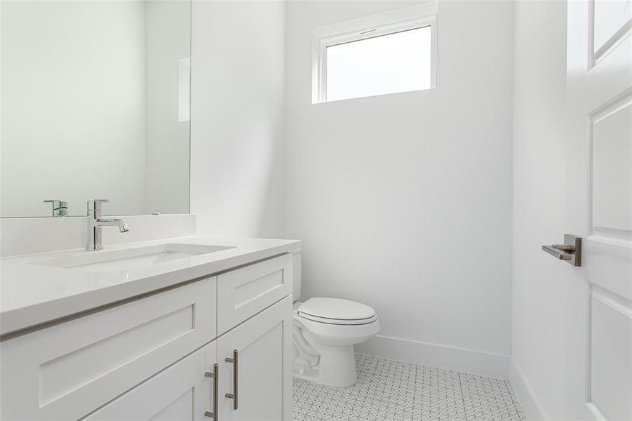 Half bath with vanity and light tile patterned flooring