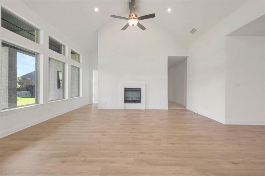 Open concept living space featuring a vaulted ceiling, recessed lighting, and a contemporary fireplace Open concept living space featuring a vaulted ceiling, recessed lighting, and a contemporary fireplace