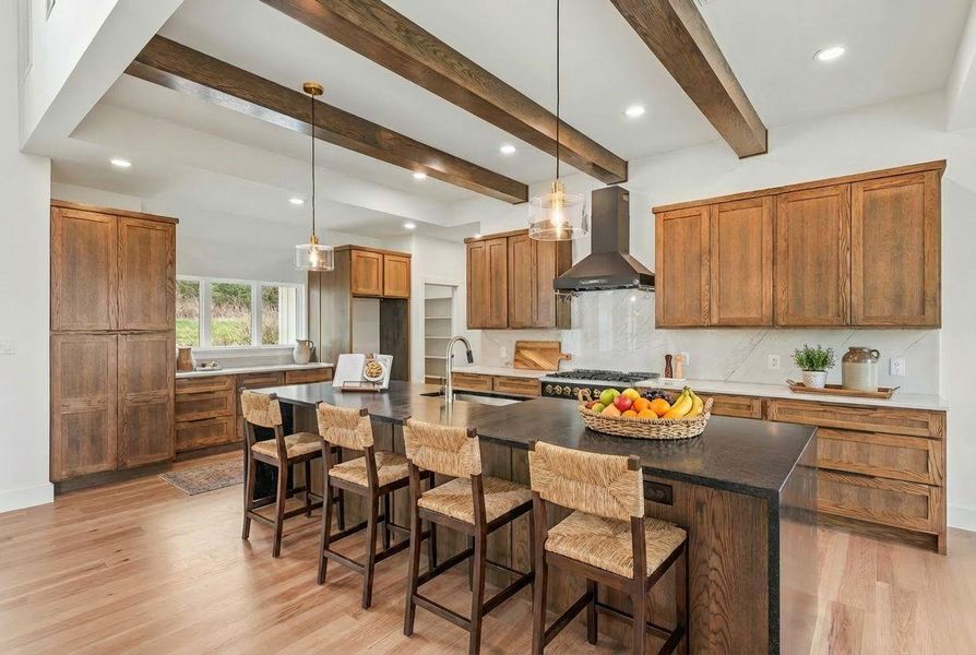 The kitchen showcases two expansive islands with exquisite quartz and granite countertops, while a full-height quartz backsplash adds both striking elegance and exceptional functionality.