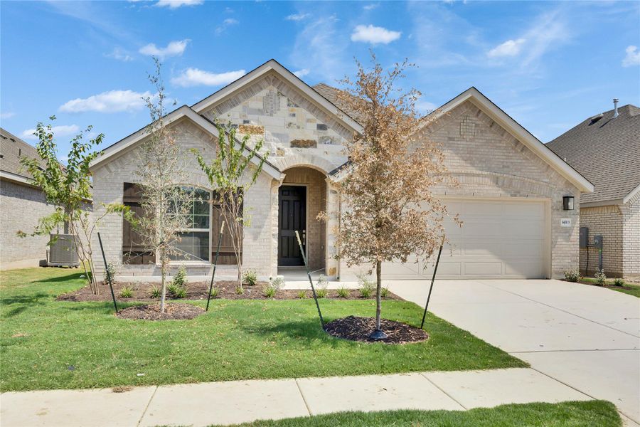 View of front of property with brick siding, an attached garage, concrete driveway, and a front yard View of front of property with brick siding, an attached garage, concrete driveway, and a front yard
