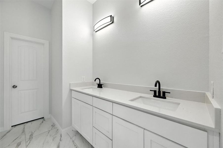 Full bathroom with double vanity and light marble finish floors