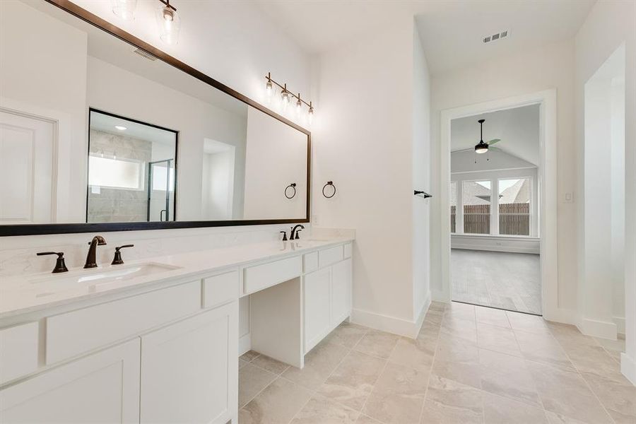 Bathroom with a shower stall, double vanity, a ceiling fan, and light tile patterned floors Bathroom with a shower stall, double vanity, a ceiling fan, and light tile patterned floors