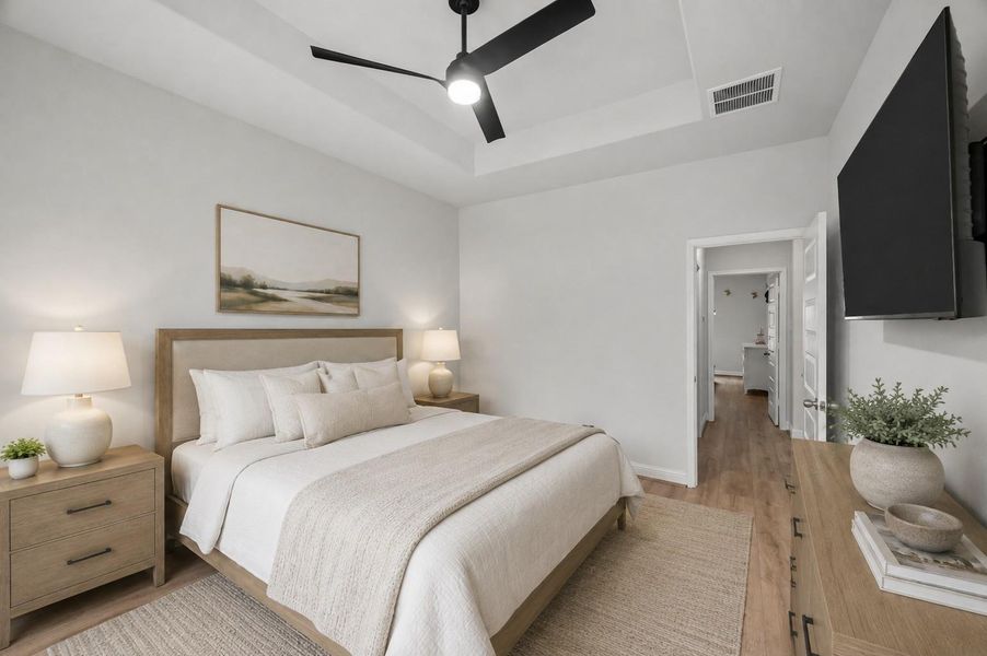 2nd bedroom with tray ceiling, modern fan, and vinyl plank flooring.