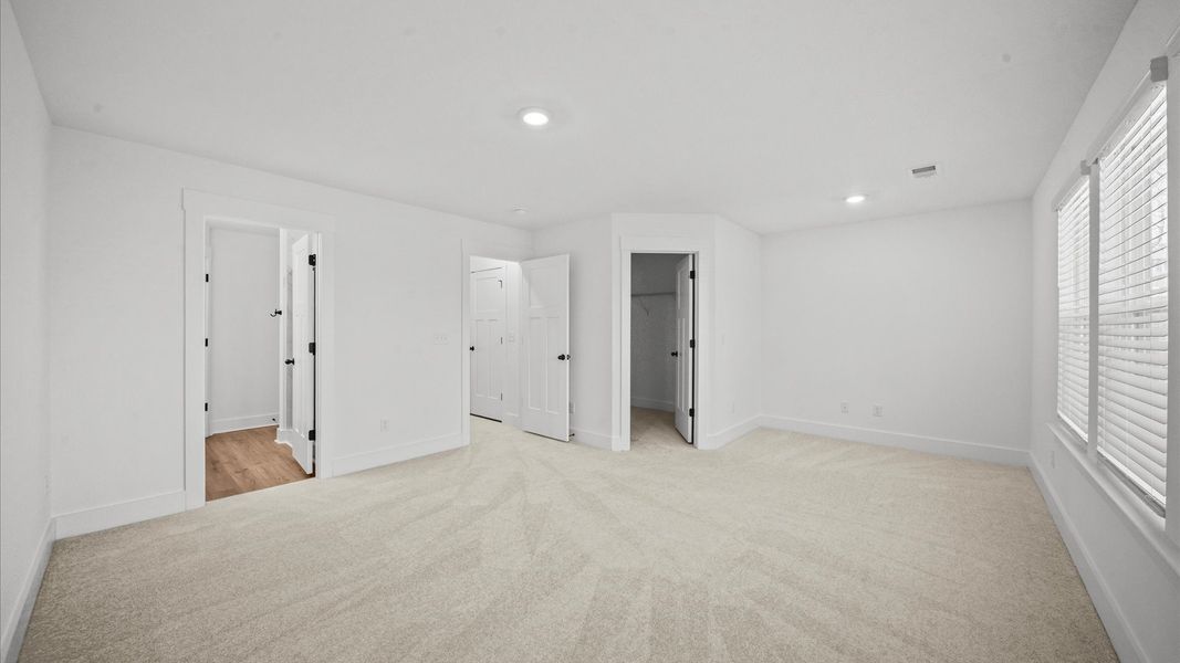 Eye-catching details and elegant finishes in the vibrant primary suite of this select townhome in Arden, NC