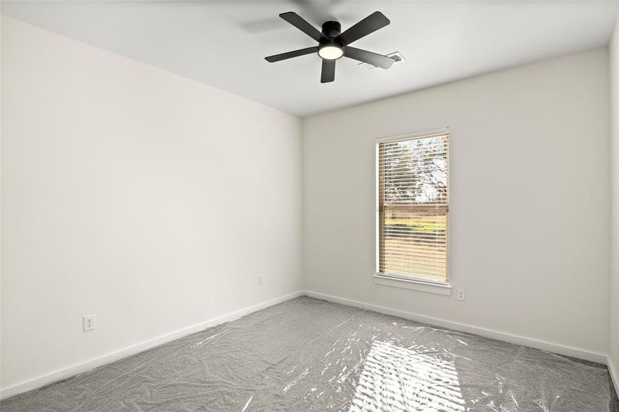Carpeted empty room with baseboards and ceiling fan