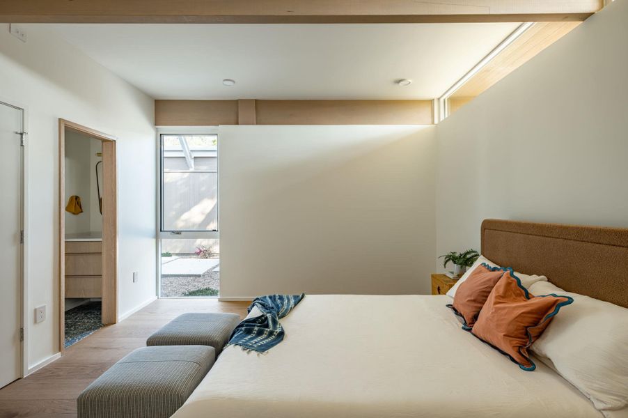 Bedroom featuring wood finished floors and ensuite bathroom