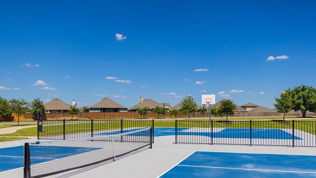 View of sport court featuring community basketball court, fence, a tennis court, and a lawn