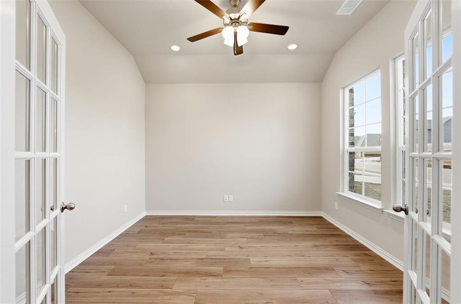Empty room featuring french doors, vaulted ceiling, light wood-style floors, recessed lighting, and ceiling fan
