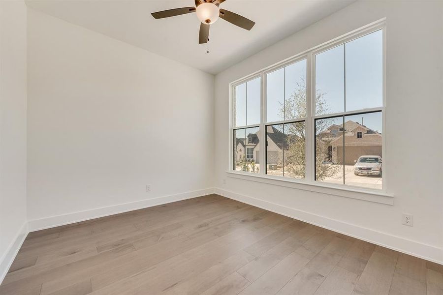 Spare room featuring light wood-type flooring, a residential view, and a ceiling fan Spare room featuring light wood-type flooring, a residential view, and a ceiling fan