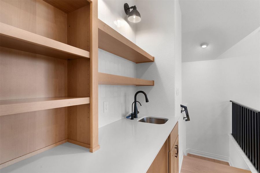 The property features a well-appointed wet bar area with a stainless steel sink, a matte black faucet, and ample counter space