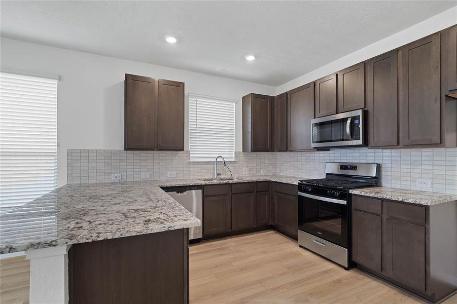 This kitchen is by far any chef’s dream! This spacious kitchen features high ceilings, wood stained cabinets, granite countertops, SS appliances, modern tile backsplash, recessed lighting, extended counter space for breakfast bar, and a walk-in pantry all overlooking your huge family room.