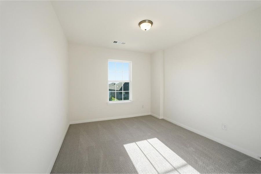 Room featuring neutral wall paint, light gray carpet flooring, and a single window with white trim