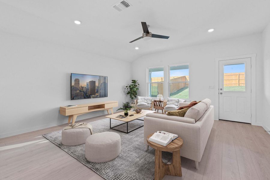 Living area featuring light wood finished floors, recessed lighting, vaulted ceiling, and a ceiling fan