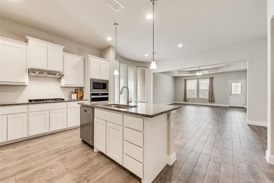 Kitchen featuring white cabinetry, a ceiling fan, decorative light fixtures, light wood-style flooring, and recessed lighting