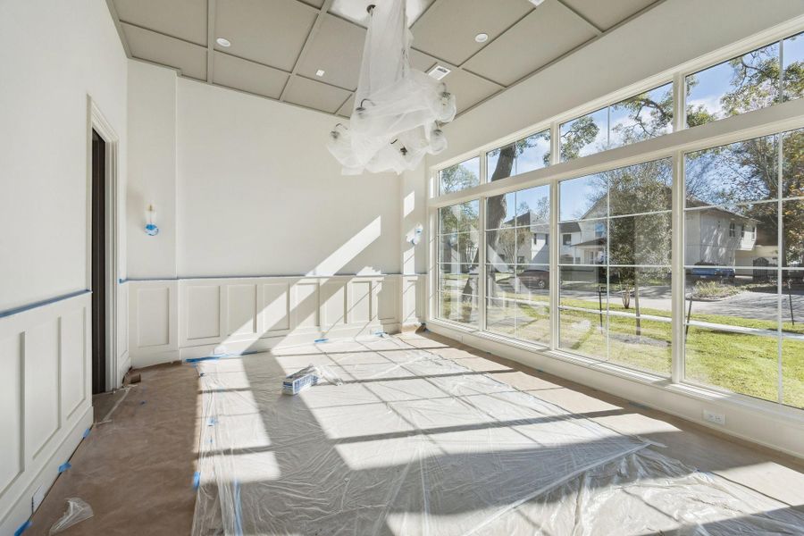 Large formal dinining room with wainscoting panels and unique ceiling detail.