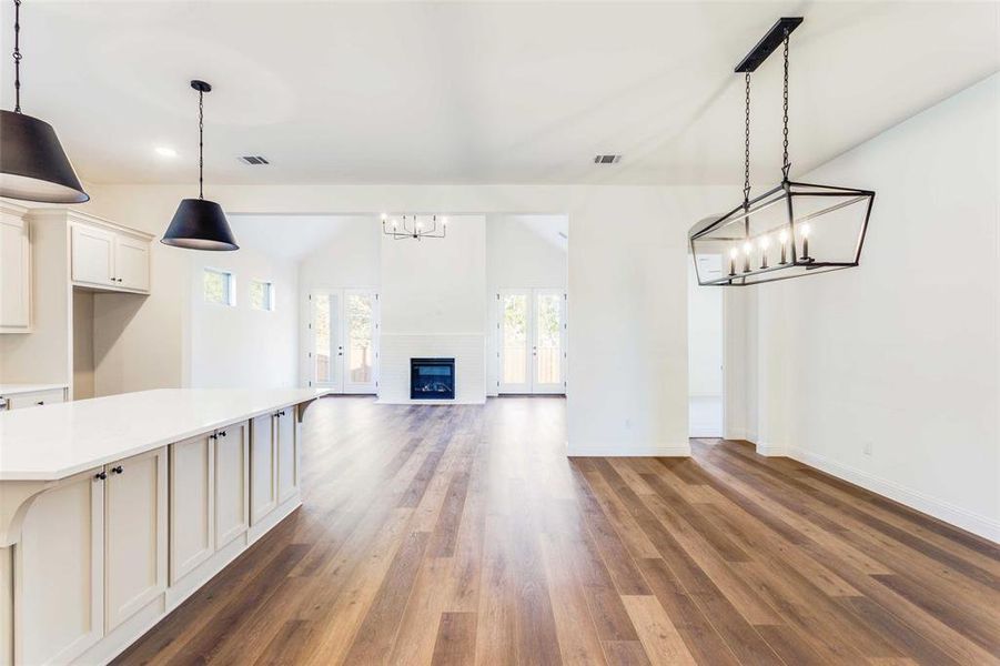 Unfurnished living room featuring hardwood / wood-style floors and vaulted ceiling