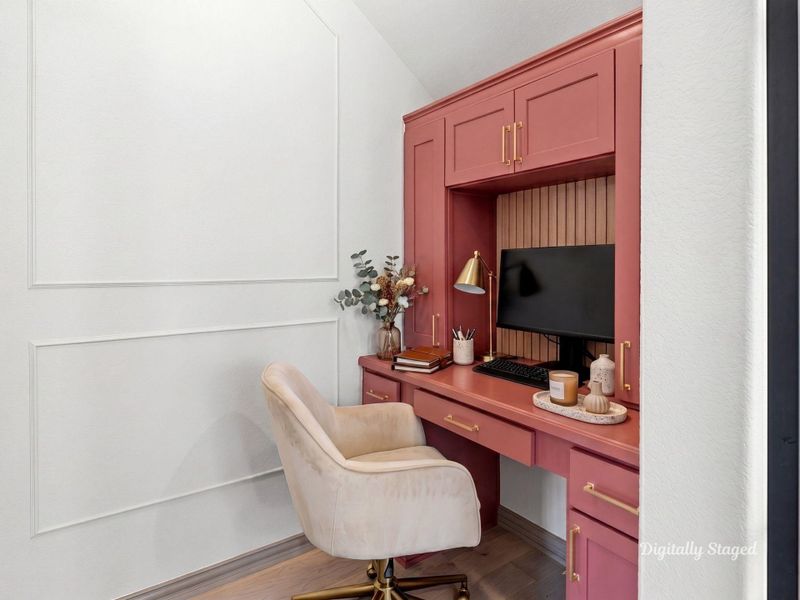 Built-in study nook tucked beneath the staircase with custom cabinetry, upper storage, and a dedicated desk surface. Framed by decorative wall molding, it makes an ideal home office or quiet work zone. This photo has been digitally staged to illustrate the possibilities of the home's aesthetic and potential design. Some furnishings and décor shown are for visual inspiration.