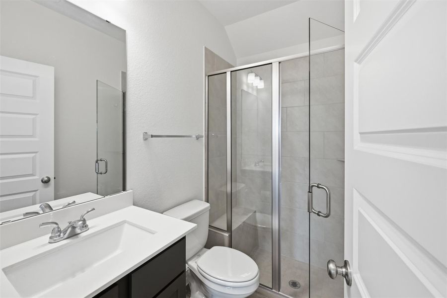 Modern bathroom featuring a sleek glass-enclosed shower, elegant vanity, and contemporary fixtures for a clean, stylish look.