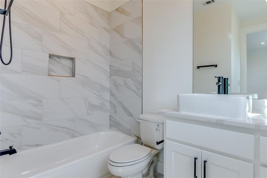 Full bathroom with vanity, toilet, and tiled shower / bath