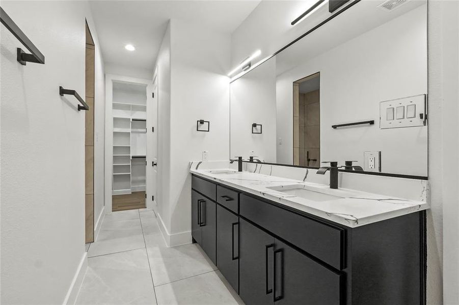 Bathroom with double vanity, light tile patterned floors, a spacious closet, and recessed lighting Bathroom with double vanity, light tile patterned floors, a spacious closet, and recessed lighting