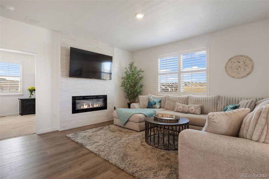 Cozy living room with a SimpliFire gas fireplace framed by floor-to-ceiling tile.