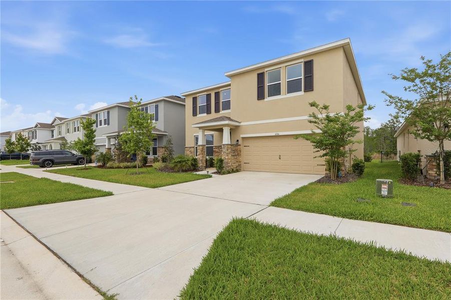 Front exterior of a new home in Deerbrook, Land O' Lakes, FL, highlighting curb appeal (Image 29).