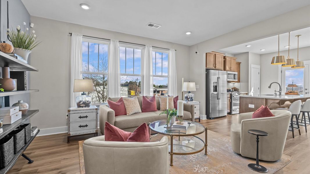 Elegant family room featuring hardwood flooring, large windows, and thoughtful architectural detail at Brookland Place