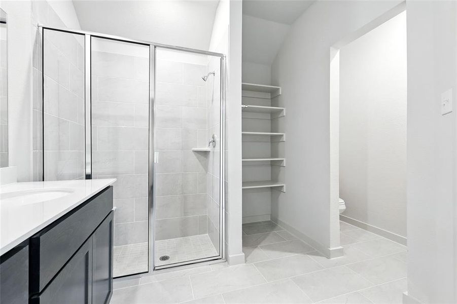 Bathroom with a stall shower, vanity, and tile patterned flooring