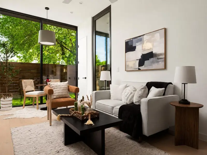 Floor-to-ceiling windows illuminate this living space with natural light, offering verdant views and seamless outdoor access. Floor-to-ceiling windows illuminate this living space with natural light, offering verdant views and seamless outdoor access.