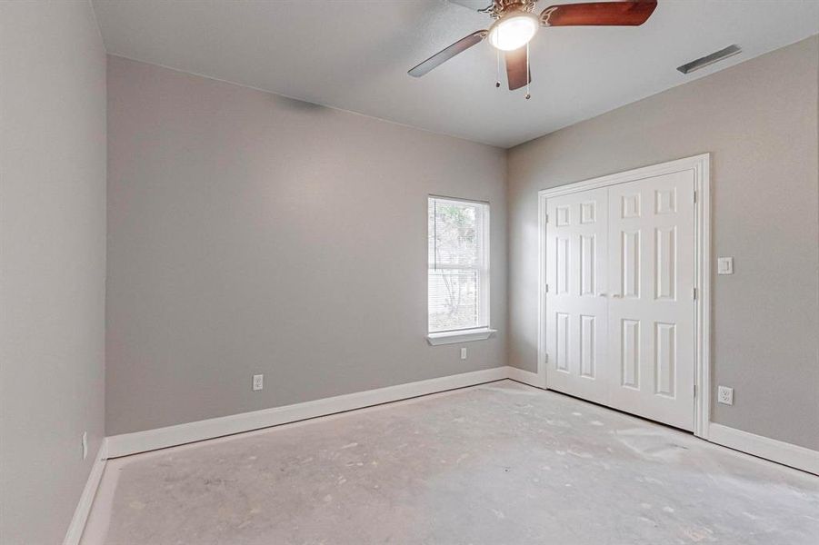 Unfurnished room featuring concrete flooring and ceiling fan