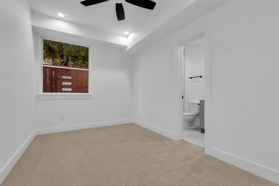 This first-floor bedroom features its own private bathroom and a walk-in closet for added convenience. Large windows provide a pleasant view of the backyard, filling the space with natural light. This first-floor bedroom features its own private bathroom and a walk-in closet for added convenience. Large windows provide a pleasant view of the backyard, filling the space with natural light.