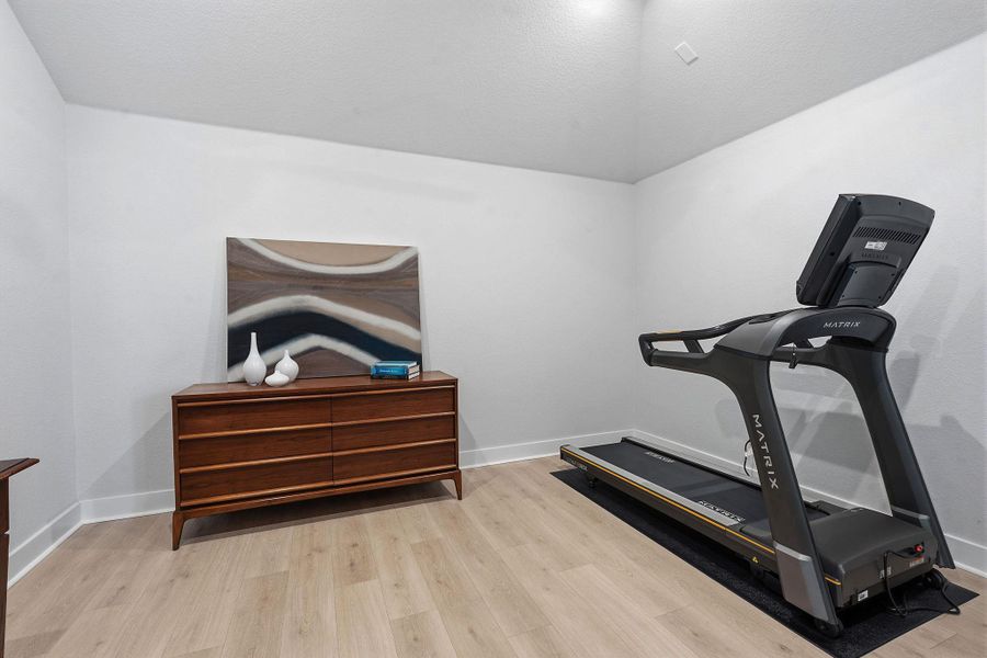 Workout room featuring light wood finished floors and baseboards