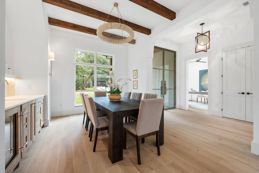 Dining area with light wood-style floors, beamed ceiling, and french doors Dining area with light wood-style floors, beamed ceiling, and french doors