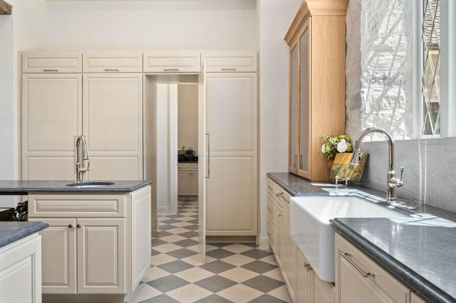 Kitchen featuring light flooring and dark stone countertops