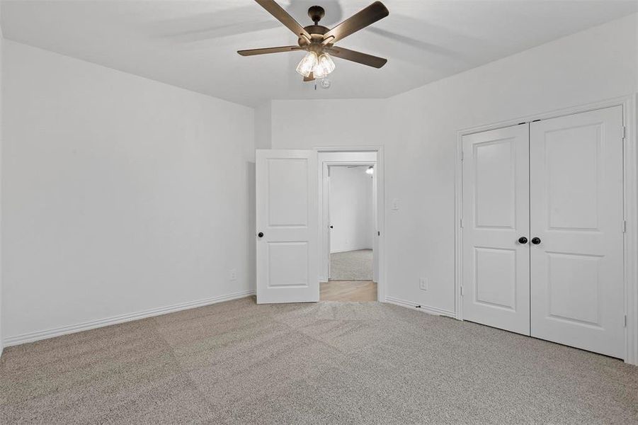 Unfurnished bedroom with a closet, light carpet, and ceiling fan