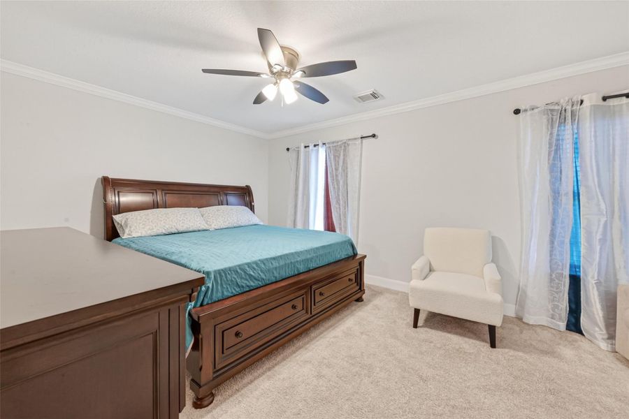 Second-level bedroom with generous proportions, ceiling fan, and natural light.
