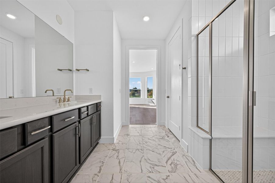 The primary bathroom features elegant finishes with dual vanities, a spacious walk-in shower.  Its bright and modern design creates a relaxing, spa-like atmosphere.